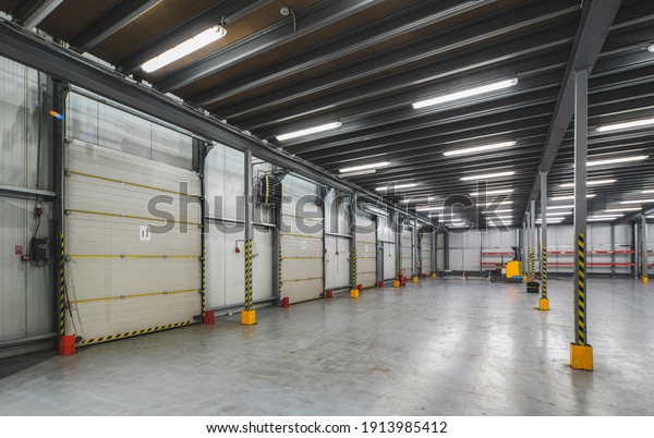 Industrial\
architecture. Modern interior of huge distribution storehouse.\
Closed doors to empty warehouse.\
Nobody.