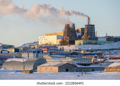 Industrial Arctic landscape. View of the thermal power plant. Smoke over large industrial chimneys. Cold and windy winter weather. Industry of the polar region. Anadyr, Chukotka, Siberia, Russia.