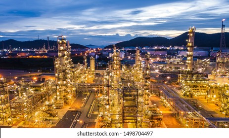 industrial area oil and gas products refinery plants and stores pipeline at twilight over lighting with blue sky background in Thailand aerial view
