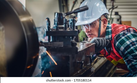 industrial background of caucasian mechanics engineer operating lathe machine for metalwork in metal work factory
