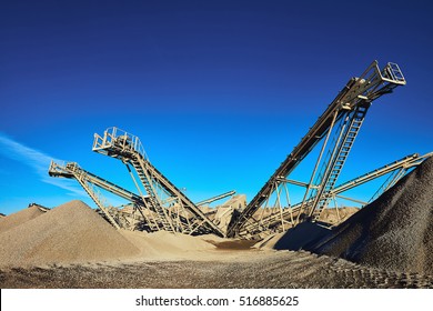 Industrial background with gravel crusher. Extraction of gravel. Conveyor for transporting gravel. Morning. Beautiful light.