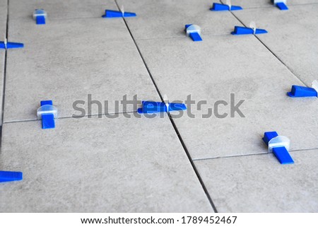 Industrial background. Tile leveling system with plastic clips and wedges, 