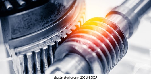 Industrial background, worm gear shaft rotation on metal gears.