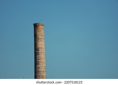 Industrial Brick Chimney Against Blue Sky