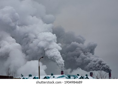 Industrial Chimneys With Heavy Smoke Causing Air Pollution On The Gray Smoky Sky Background