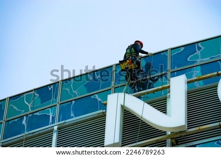 an industrial climber descends from the roof of a building. close-up