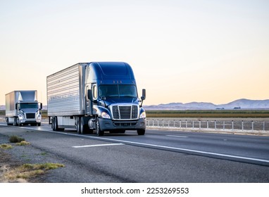 Industrial Grade Black Classic Shiny Big Rig Semi Truck Tractor With Chrome  Accessories And Massive Grille Guard And Flat Bed Semi Trailer Standing On  The Truck Stop Parking Lot For Truck Driver