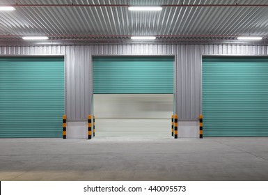 Industrial Or Commercial Building Exterior. Use As Factory, Warehouse, Store And Workplace. Safety And Protection With Roller Door, Roller Shutter Or Overhead Door. Concrete Pavement Floor Outside.