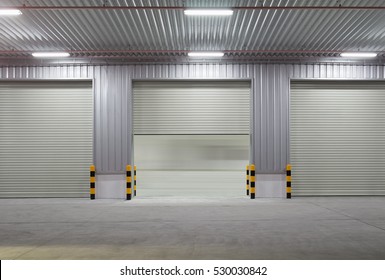 Industrial Or Commercial Building Exterior. Use As Factory, Warehouse, Store And Workplace. Safety And Protection With Roller Door, Roller Shutter Or Overhead Door. Concrete Pavement Floor Outside.