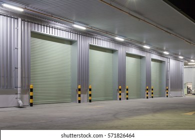 Industrial Or Commercial Building Exterior. Use As Factory, Warehouse, Store And Workplace. Safety And Protection With Roller Door, Roller Shutter Or Overhead Door. Concrete Pavement Floor Outside.