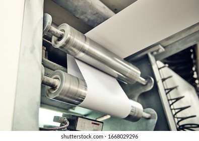 A industrial commercial envelope making machine, making paper envelopes for international distribution. Automated engineering machinery for mass production of paper envelopes. - Shutterstock ID 1668029296