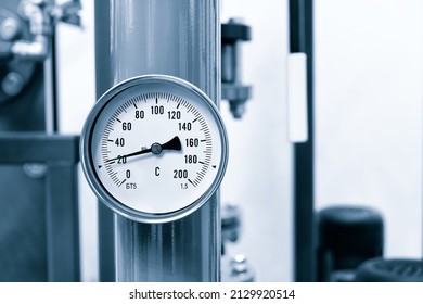 Industrial  concept. equipment of the boiler-house, - valves, tubes, pressure gauges, thermometer. Close up of manometer, pipe, flow meter, water pumps and valves of heating system in a boiler room. - Powered by Shutterstock