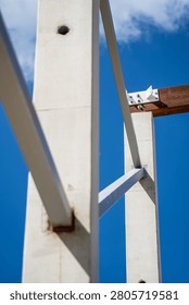 Industrial construction framework consisting of vertical concrete posts and metal braces connected to timber beams for sturdy building support