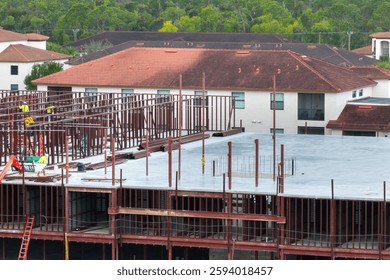 Industrial construction site with workers assembling metal frame building. Development of residential housing in America. Real estate market in the USA