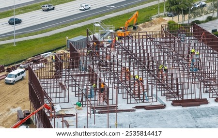 Industrial construction site with workers assembling metal frame building. Development of residential housing in America. Real estate market in the USA