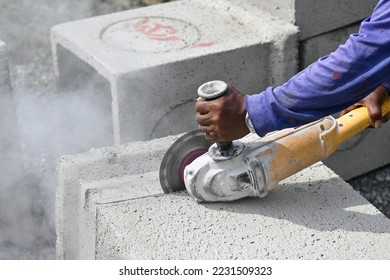 Industrial construction worker using a professional angle grinder cutting the concrete Block - Shutterstock ID 2231509323