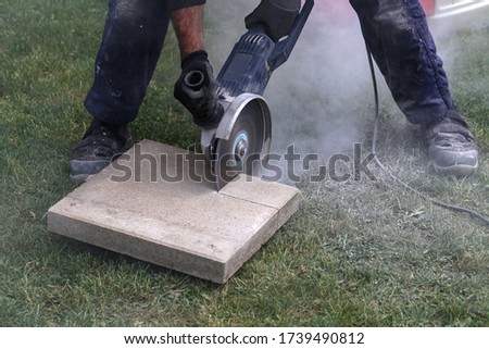 Industrial construction worker using a professional angle grinder.