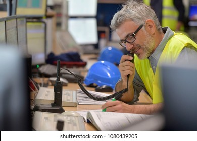 Industrial Control Room Supervisor Using Radio To Give Instructions