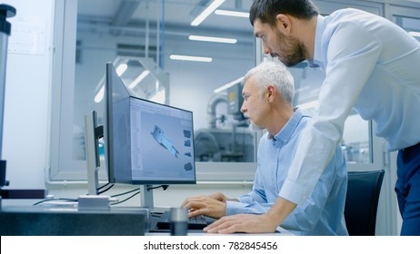 Industrial Designer Has Discussion With Senior Engineer While Working In CAD Program, Designing New Component. He Works On Personal Computer With Two Monitors.