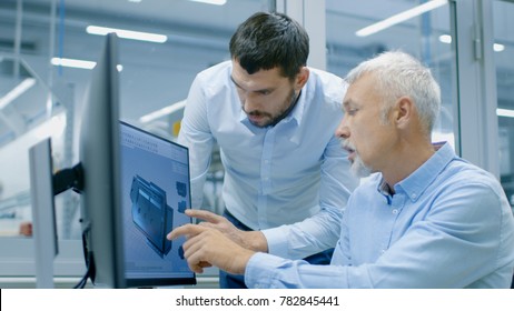 Industrial Designer Has Product Discussion with Senior Engineer While Working in CAD Program, Designing New Component. He Works on Personal Computer with Two Monitors.