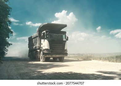 Industrial dump truck, transportation of stones, rides on  dusty road. Career work