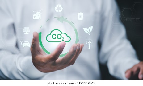 Industrial Emissions Pollute The Environment And Ecosystems. Including Climate Change Carbon Renewable Energy Agreement Reduce Greenhouse Gas Emissions , Businessman Holding Icon In Hand