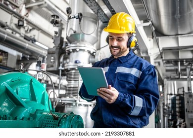 Industrial Engineer Standing By Gas Generator In Power Plant And Controlling Electricity Production On His Tablet.