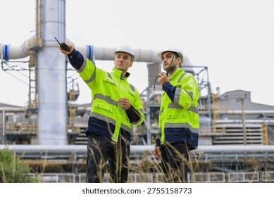  Industrial Engineer Using Digital Tablet for Predictive Maintenance in Oil and Gas Refinery. Team of Engineers Discussing Safety Protocols at Large Scale Oil Refinery Facility. group of industrial engineers workers in a refinery - oil and gas processing equipment and machinery, engineers collaborate with a laptop, blueprint, and digital tablet at the oil storage tanks site.
