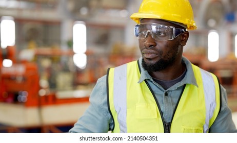 Industrial Engineer Worker Wiping The Sweat Away From Forehead Taking Off Yellow Safety Hard Hat Feeling Tired In Job And Tight In Safety Uniform Taking A Break Beside Row Of Machine