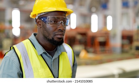 Industrial Engineer Worker Wiping The Sweat Away From Forehead Taking Off Yellow Safety Hard Hat Feeling Tired In Job And Tight In Safety Uniform Taking A Break Beside Row Of Machine