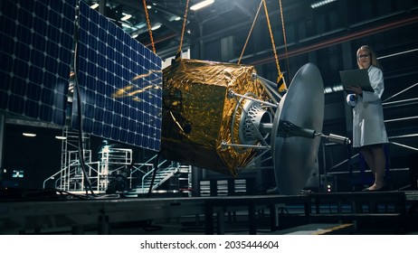 Industrial Engineer Working On Artificial Satellite Construction. Aerospace Agency: Female Scientist Using Laptop Computer To Develop Spacecraft For Space Exploration And Data Communication.