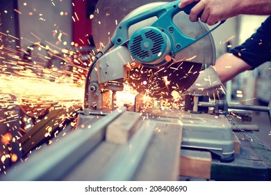 industrial engineer working on cutting a metal and steel with compound mitre saw with sharp, circular blade