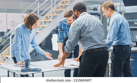 In the Industrial Engineering Facility: Diverse Group of Engineers and Technicians on a Meeting Gather Around Table Unravel Sheets of Engine Design Technical Drafts, Have Discussion, Analyse Drawings. - Powered by Shutterstock