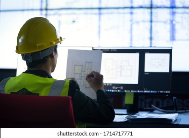 Industrial Engineering Works In Front Of Monitoring Screen In The  Control Center Office. Technology And Artificial Intelligence Concept.