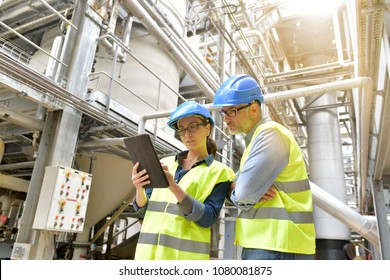 Industrial engineers working in recycling plant with tablet