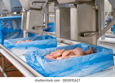 Industrial Equipment At A Meat Factory. Meat Processing Plant. Meat Processing Equipment. Production Line With Packaging And Cutting Of Meat.