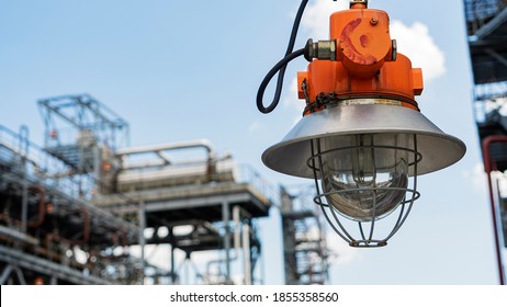 Industrial explosion proof lantern on the background of the refinery plant and classic blue sky.