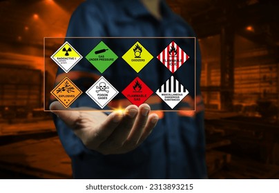 Industrial factory safety officers hold chemical hazard warning signs in their hands to remind close workers to be aware of the dangers of chemicals in dangerous goods transport and handling concept.