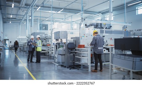 Industrial Factory: Team of Engineers, Technicians and Workers, Working on Production Plant, Developing CNC Parts, Programming Machines. Two Specialists Discussing Project Plan and Using Laptop. - Powered by Shutterstock