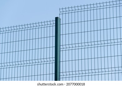 Industrial Fencing Made Of Heavy Duty Metal Wire On A Background Blue Sky