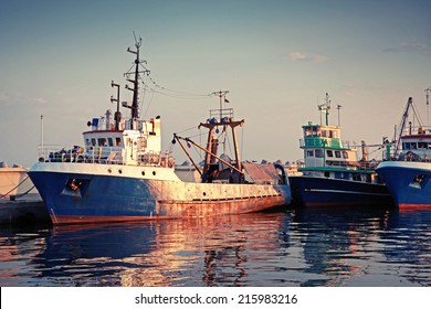 Industrial Fishing Boats Are Moored In Port. Vintage Toned Photo