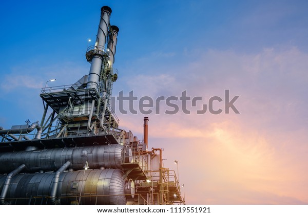 Industrial furnace and heat exchanger cracking\
hydrocarbons in factory on blue sky sunset background, Close up of\
equipment in petrochemical plant at\
evening