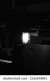 Industrial Grade Mechanical Work Light Shining When Hung Below The Train Engine In Black And White.