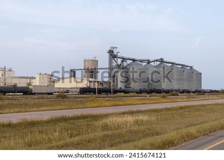 Industrial Grain Silo Complex with Train Loading Facility at Sunset