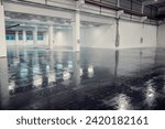 Industrial hall is covered in black epxy resin by a worker