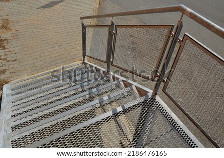 industrial hall, warehouse has a side door at a steep staircase with high resistance even under heavy load galvanized steel floor grate and railings. expanded metal, edges of stairs of safety yellow 