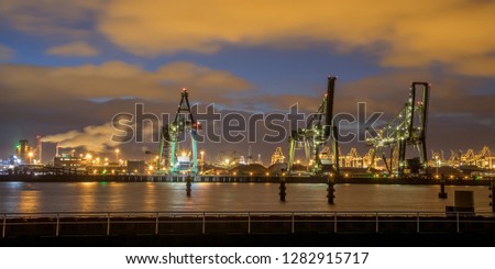Industrial Harbor quay with loading cranes at night in Europoort Maasvlakte Port of Rotterdam Netherlands