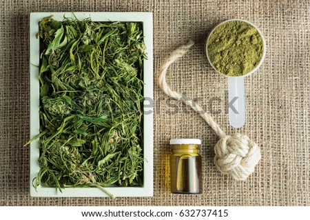 Industrial hemp plant products: tea, oil, rope and protein powder on 100% hemp fabric