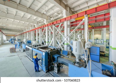 Industrial injection molding press machine for the manufacture of plastic parts using polymers in the management of worker - Shutterstock ID 537060823