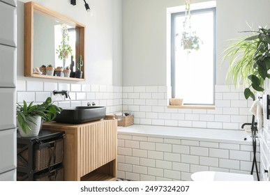 Industrial interior of modern bathroom with bath, window and black wash basin on wooden cabinet. Loft apartment.